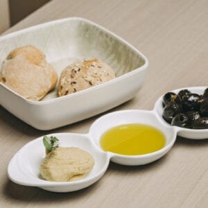 Pão, azeite, azeitonas marinadas, hummus