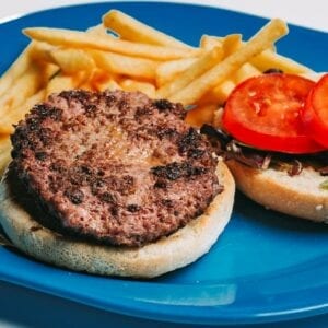 Hamburguer de novilho em pão, batatas fritas e salada